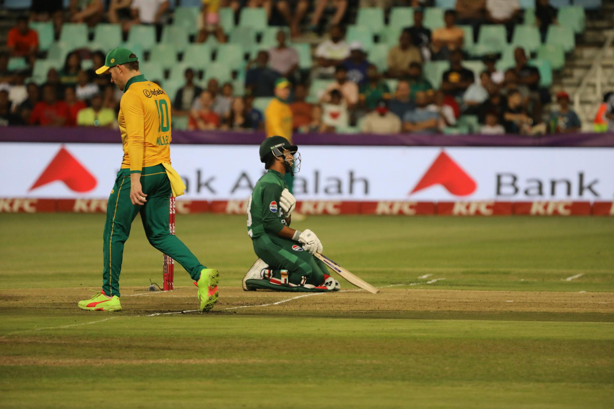Dynamic cricket scene with players in action on the field during a match.
